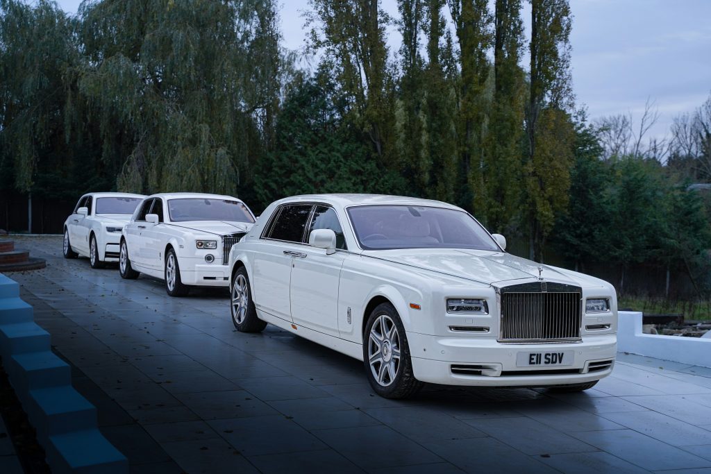 eine-reihe-weisser-rolls-royces-parkt-am-strassenrand-pATu9FKnxwY