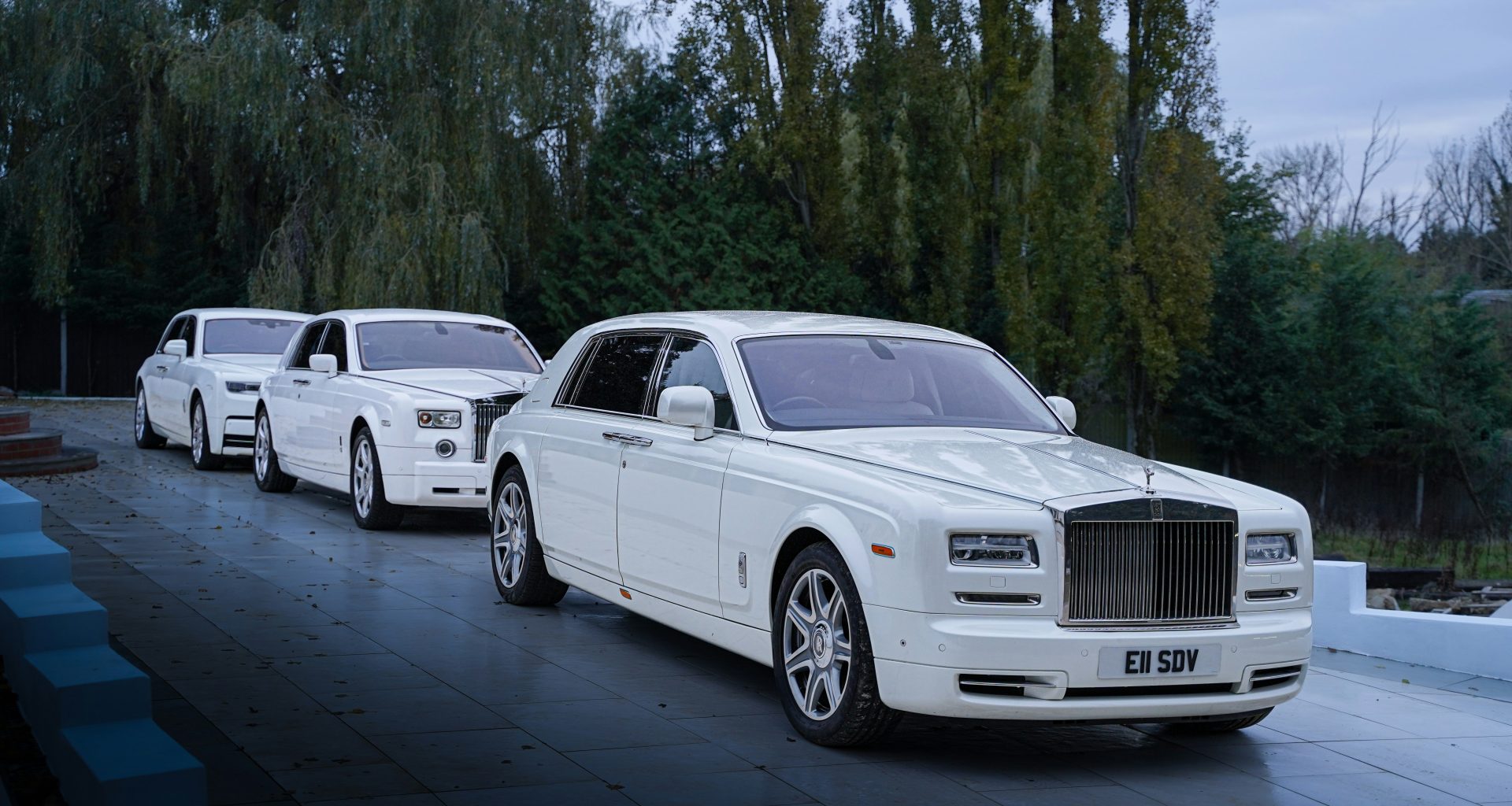 eine-reihe-weisser-rolls-royces-parkt-am-strassenrand-pATu9FKnxwY