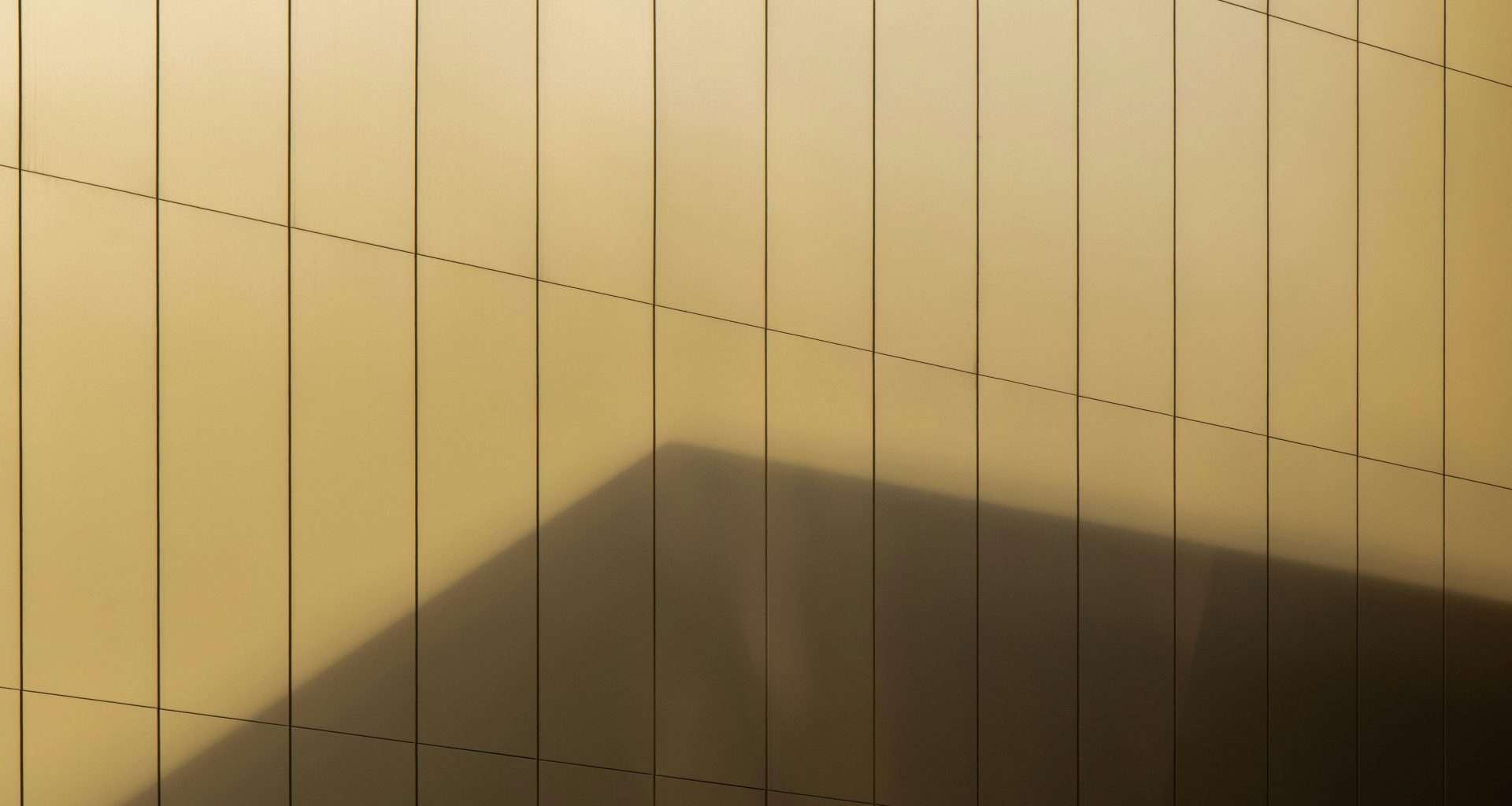 ein-schatten-eines-gebaudes-an-einer-wand-DNaNWLjDNsU