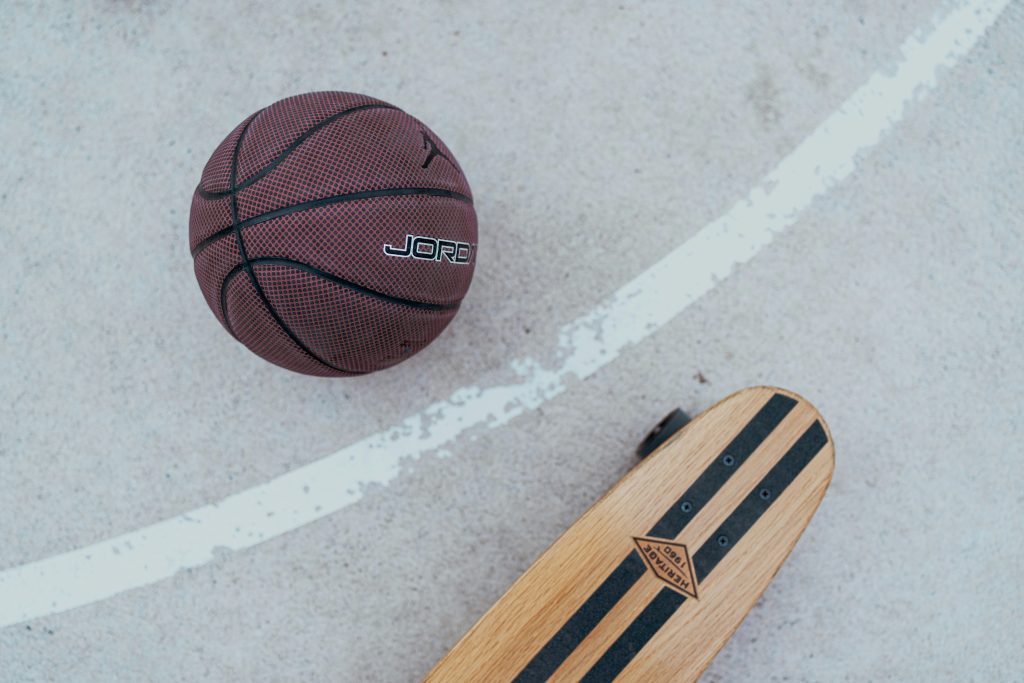 ein-skateboard-und-ein-basketball-auf-dem-boden-y6PugSs0i7k