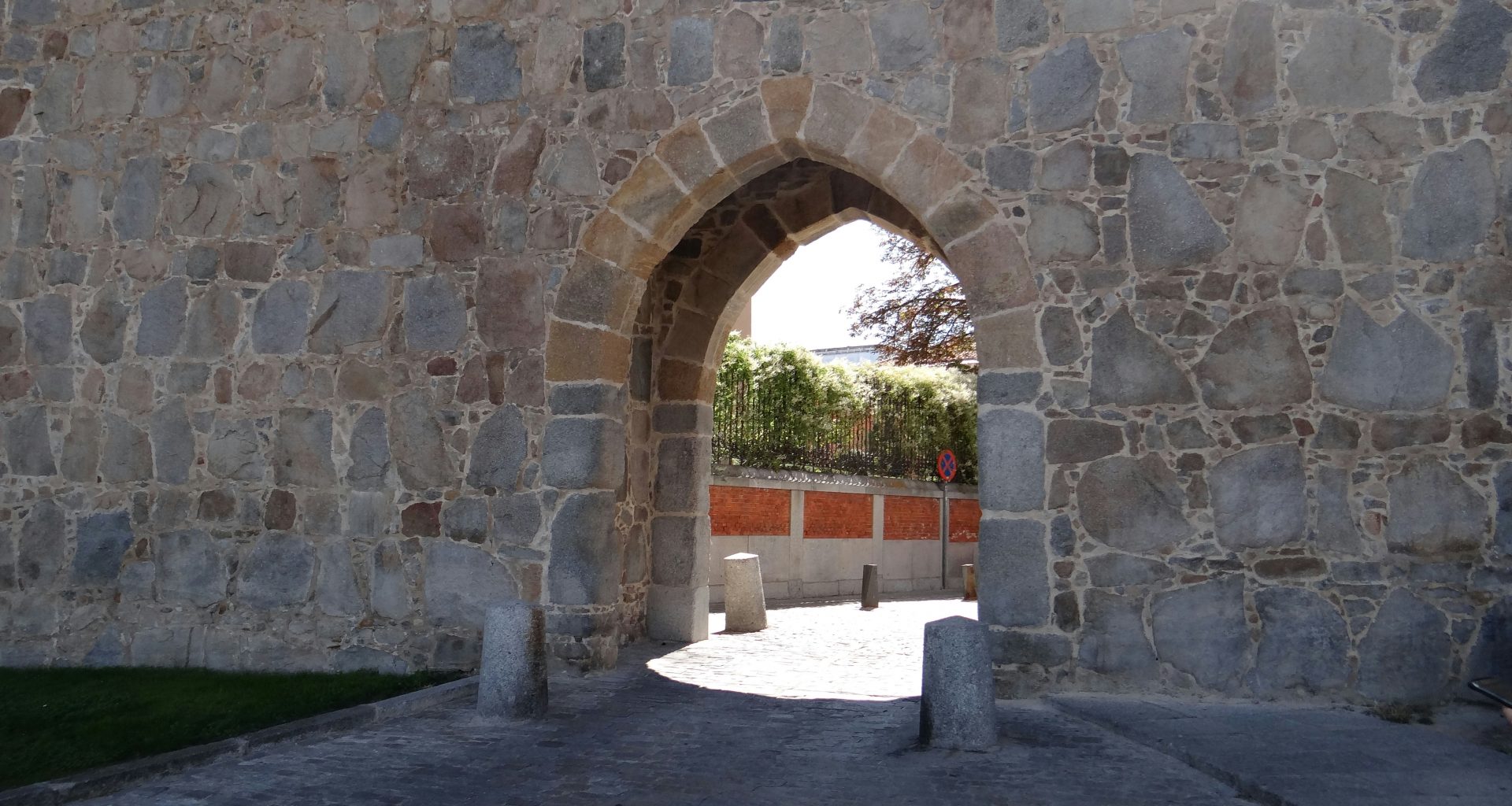 eine-steinmauer-mit-einem-gewolbten-portal-l5RMuGlaOTY