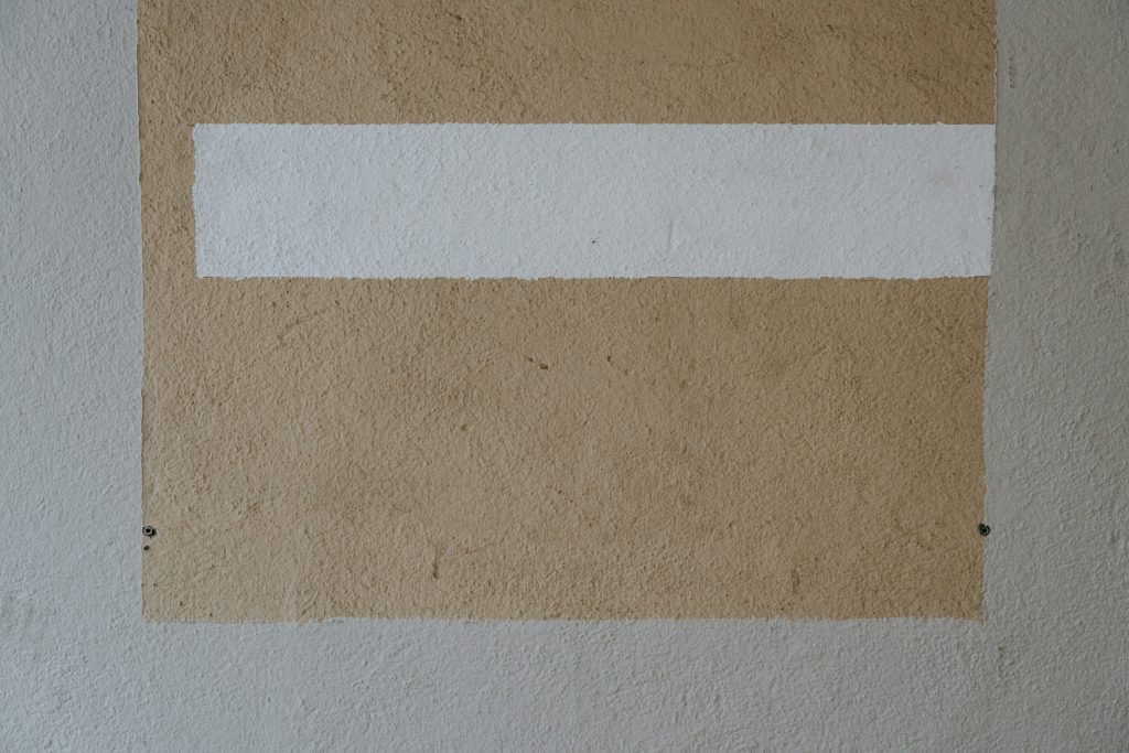 ein-weiss-braunes-gemalde-an-einer-wand-12imFfEE1hc