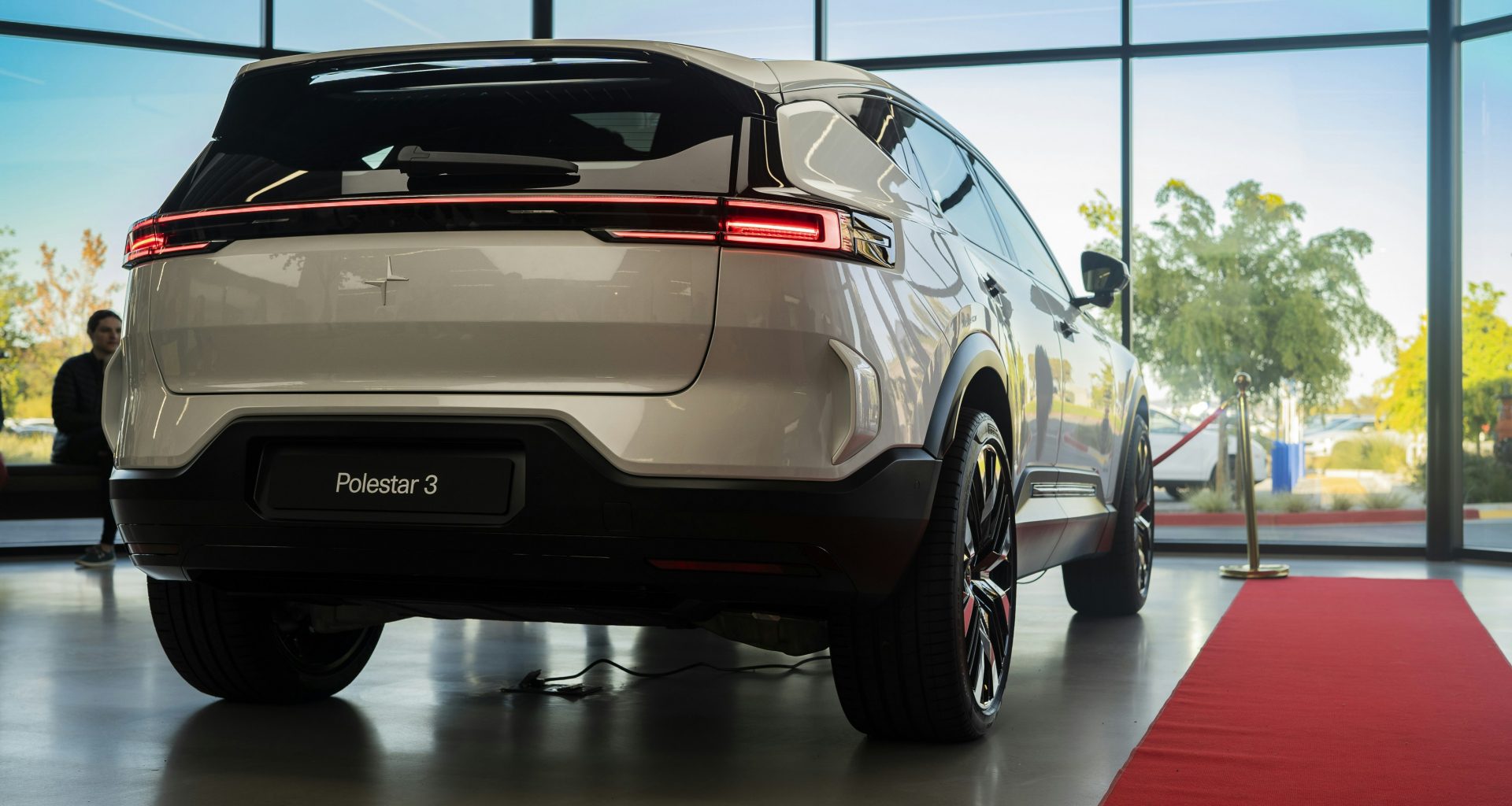 ein-weisses-auto-das-vor-einem-grossen-fenster-geparkt-ist-8l9I2JBBcmY