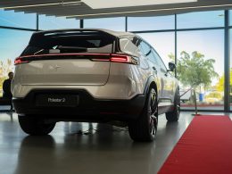 ein-weisses-auto-das-vor-einem-grossen-fenster-geparkt-ist-8l9I2JBBcmY