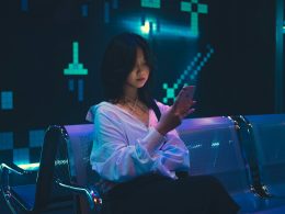 eine-frau-die-mit-einem-handy-auf-einer-bank-sitzt-DSSZYpM0V1I