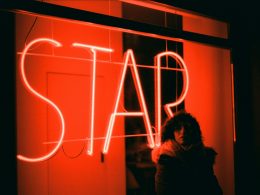 eine-frau-steht-vor-einer-leuchtreklame-9-oNehIJqRY