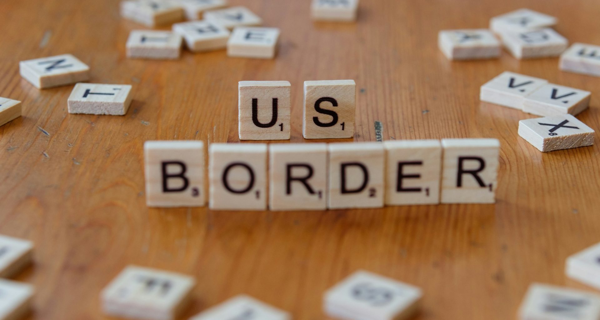 ein-holztisch-mit-scrabble-kacheln-die-uns-grenze-buchstabieren-j3VI1n73qNk