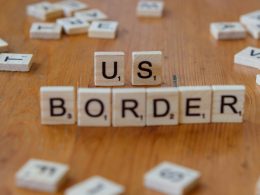 ein-holztisch-mit-scrabble-kacheln-die-uns-grenze-buchstabieren-j3VI1n73qNk