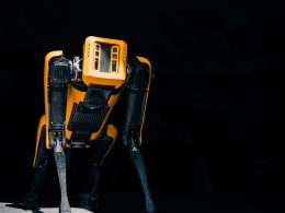 ein-gelb-schwarzer-roboter-der-im-dunkeln-steht-xtt9ohgbZu4