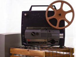 ein-alter-filmprojektor-sitzt-auf-einem-tisch-FWkYZBUs7e0