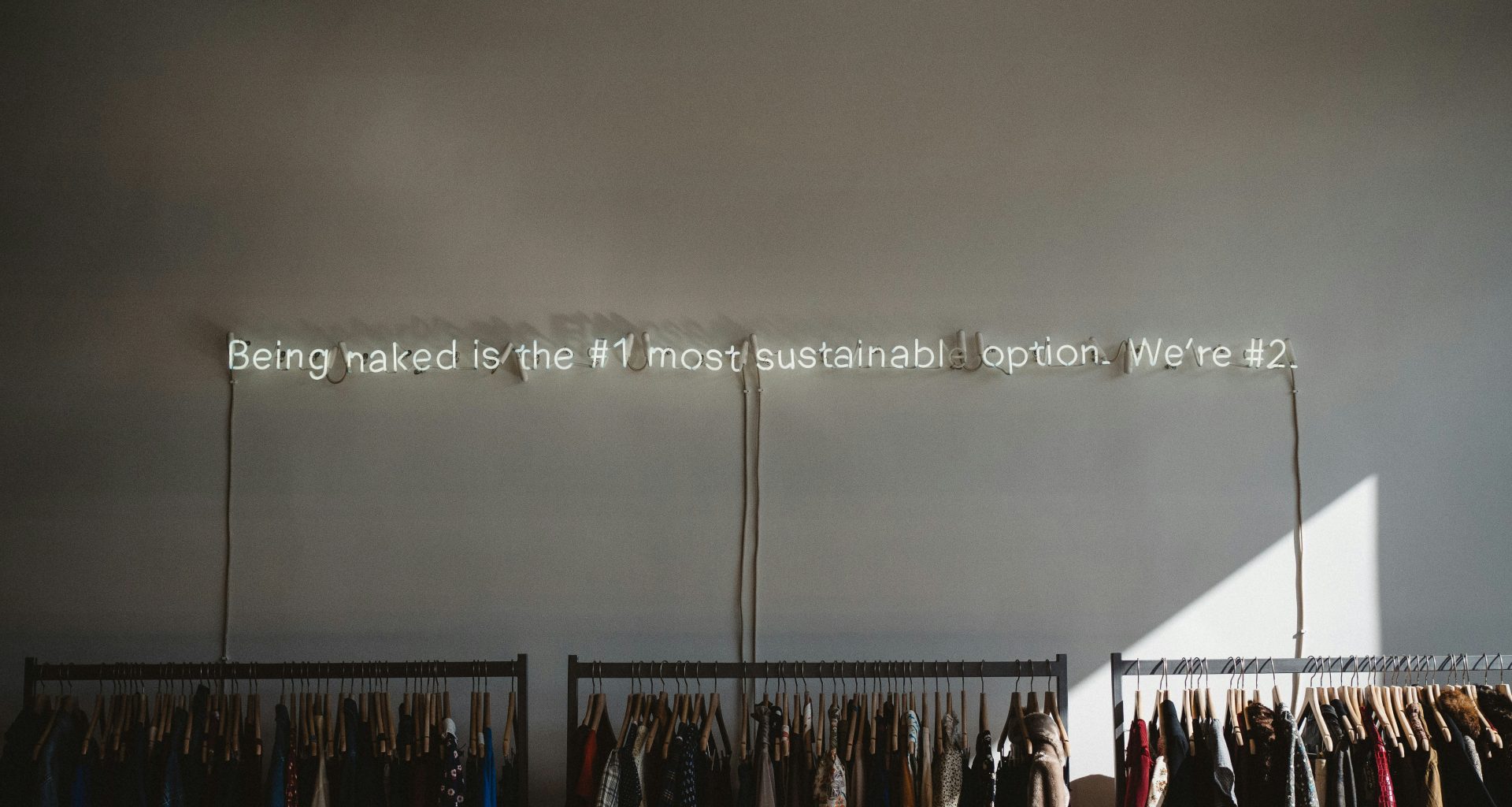 sortierte-kleidungsstucke-auf-grauen-kleiderstandern-k78R0lDxd48