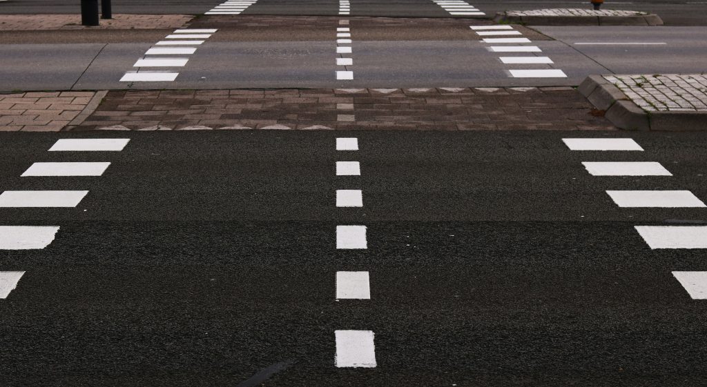 schwarz-graue-betonstrasse-mit-weissen-fahrspuren-2obgPG_cY2Q