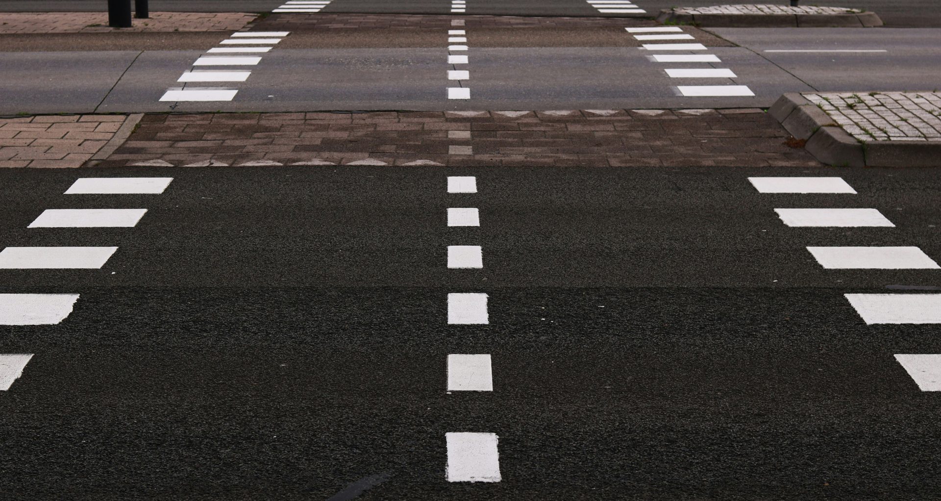 schwarz-graue-betonstrasse-mit-weissen-fahrspuren-2obgPG_cY2Q