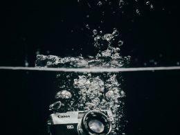 schwarz-silberne-dslr-kamera-auf-glas-Ii0SqNV7e8I