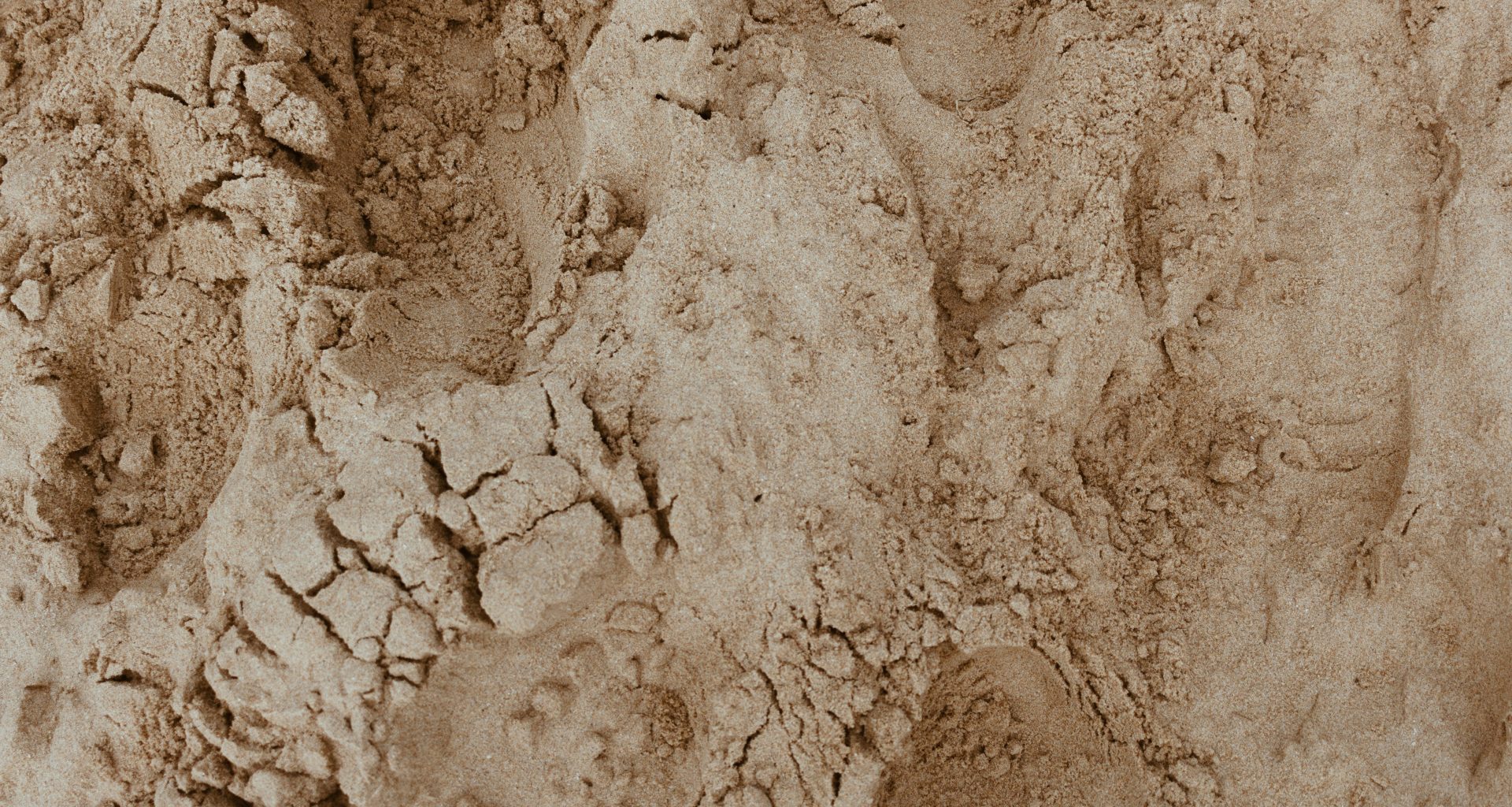 brauner-sand-mit-wasser-tagsuber-LCpuZbvyufo