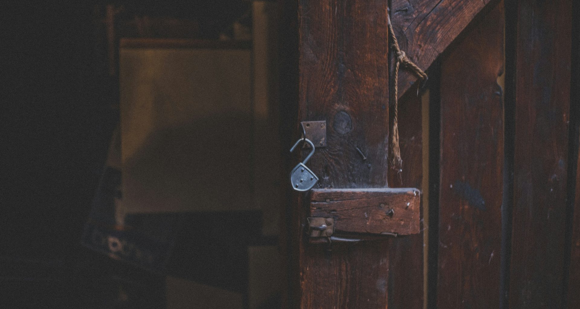 braune-holztur-mit-silbernem-vorhangeschloss-FFsUZLR0pro