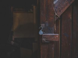 braune-holztur-mit-silbernem-vorhangeschloss-FFsUZLR0pro