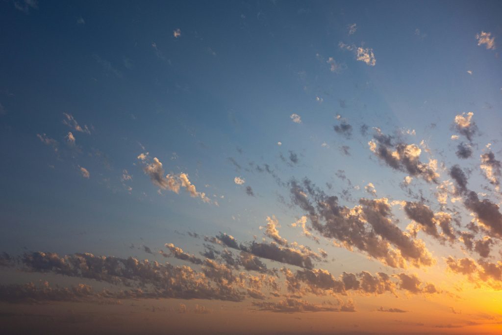 vogelschwarm-der-bei-sonnenuntergang-uber-die-wolken-fliegt-5QIlud91vr0