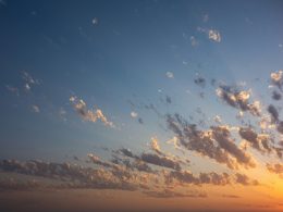 vogelschwarm-der-bei-sonnenuntergang-uber-die-wolken-fliegt-5QIlud91vr0