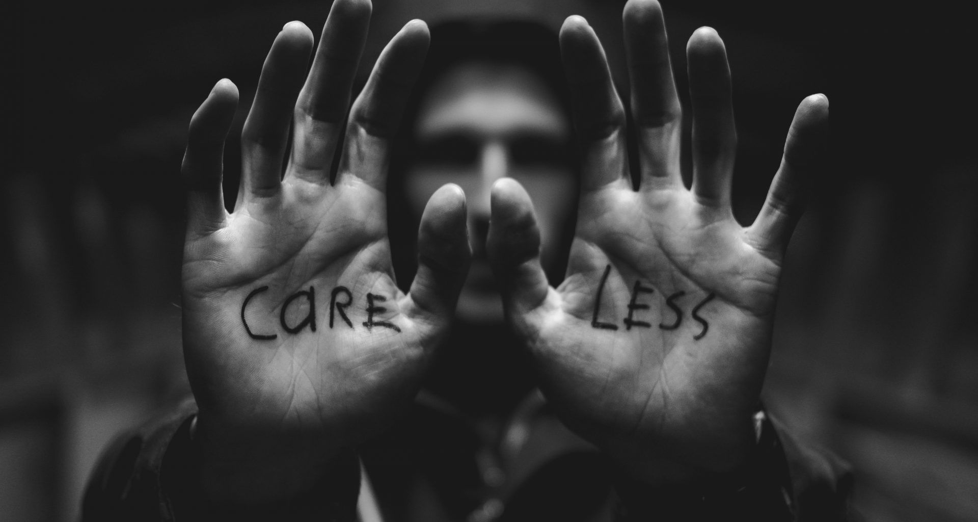 graustufenfotografie-eines-mannes-der-beide-hande-mit-sorglosem-text-auf-der-handflache-hebt-bFAamvcm5kc