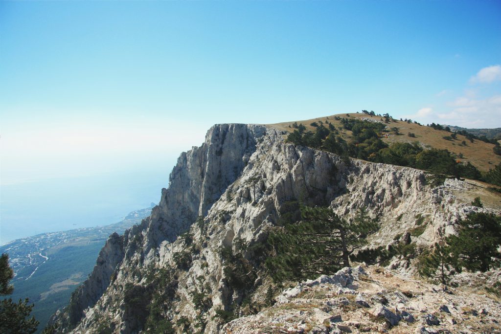 gruner-und-grauer-berg-unter-blauem-himmel-tagsuber-3bXR0eZm2i8