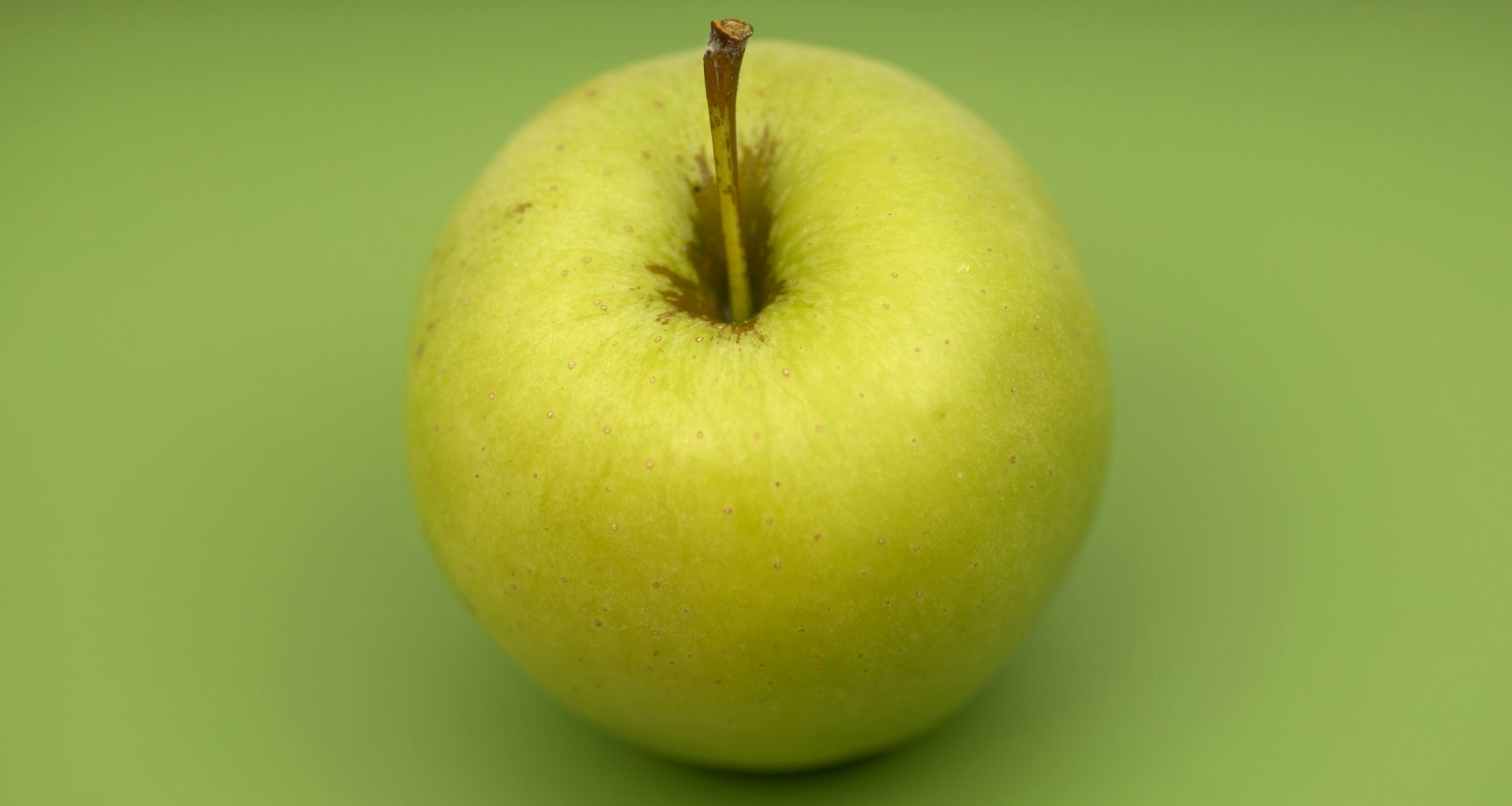 grune-apfelfrucht-auf-gruner-flache-vUzCqykkFtE