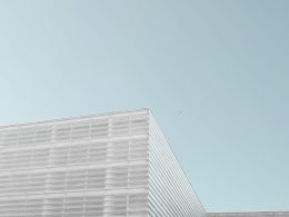 graues-betongebaude-unter-strahlend-blauem-himmel-cqK6Ysfhhb0