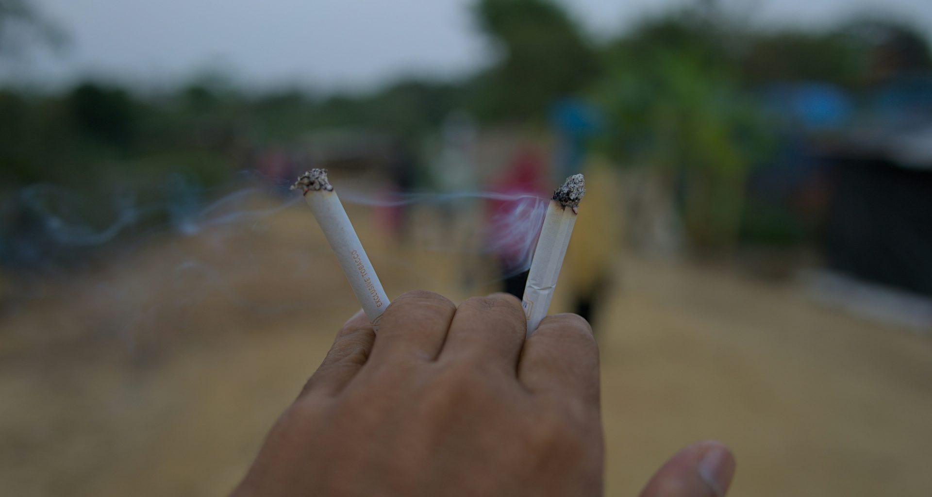 die-hand-halt-zwei-brennende-zigaretten-mit-rauch-CxNwDYGWsmc