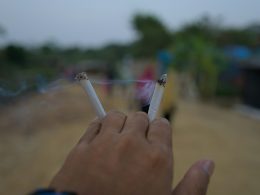 die-hand-halt-zwei-brennende-zigaretten-mit-rauch-CxNwDYGWsmc