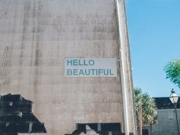 hallo-schon-bedruckte-braune-betonwand-mit-fast-weissem-holzhaus-jbroe3pOt8M