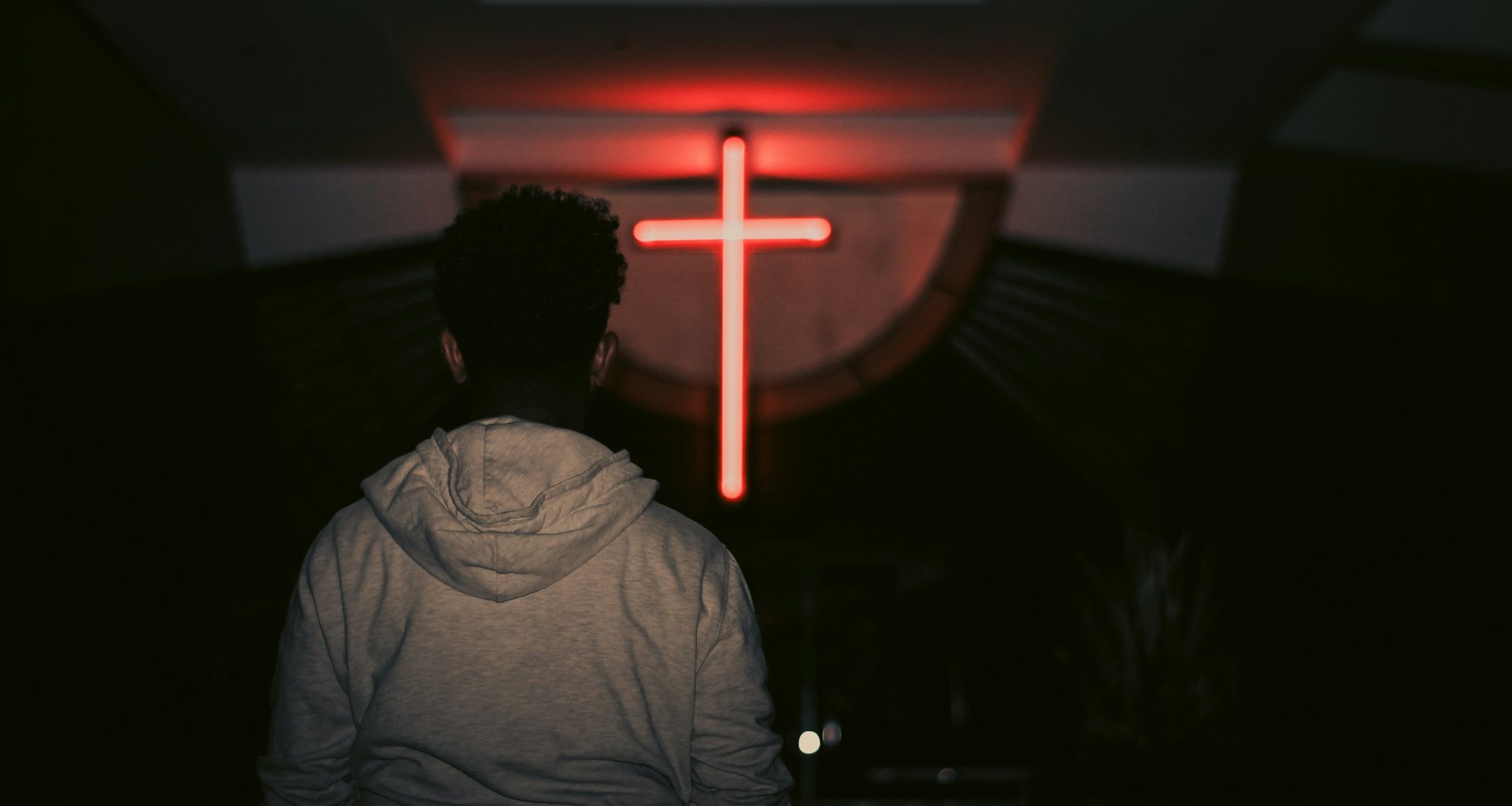 mann-blickt-auf-rotes-led-kreuz-q9X1okaox0w