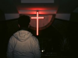 mann-blickt-auf-rotes-led-kreuz-q9X1okaox0w