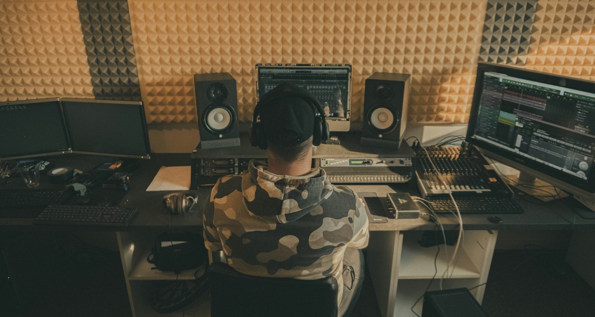 mann-in-schwarz-weissem-tarnhemd-sitzt-neben-schwarzer-computertastatur-cnSJRKwJxSA