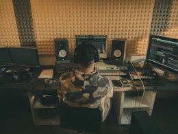 mann-in-schwarz-weissem-tarnhemd-sitzt-neben-schwarzer-computertastatur-cnSJRKwJxSA