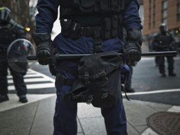 mann-in-schwarzer-lederjacke-mit-gewehr-Ym_S9PsKGgU