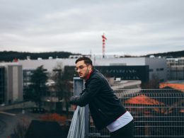 mann-steht-neben-gelander-L-4Xbxkmy9g