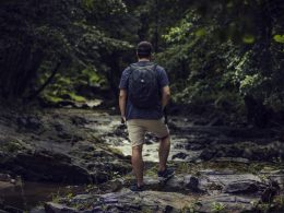 mann-steht-auf-felsen-in-der-nahe-eines-gewassers-C-Vrn4RPIs0