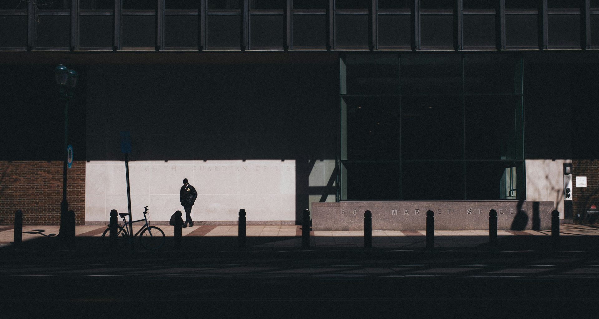 mann-zu-fuss-in-der-nahe-von-fahrrad-neben-gebaude-TzaJgKf-0U0