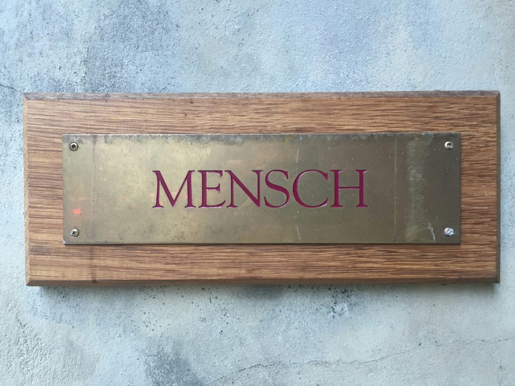 mensch-messingplatte-auf-holzblock-an-der-wand-angebracht-EOQ1x-CGe-M
