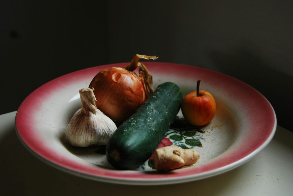 zwiebeln-knoblauch-ingwer-und-grunes-gemuse-auf-rundem-weissem-und-rotem-teller-VOE-n32iZf0