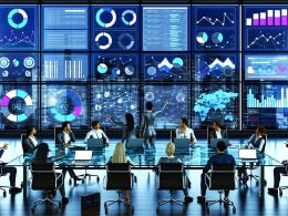 Business-Team diskutiert an einem Glastisch im modernen Kontrollraum vor digitalen Dashboards mit KPIs und Diagrammen, umgeben von Laptops, Kaffeetassen und urbaner Skyline.
