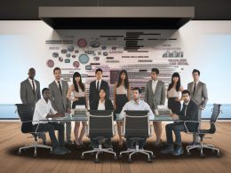 Marketingteam in modernem Büro betrachtet verständnislos komplexe digitale Daten auf Bildschirm mit technischen Begriffen; kreativer und technischer Gegensatz sichtbar.