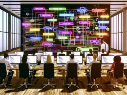 Team aus Entwicklern und SEO-Experten arbeitet konzentriert an einem digitalen Whiteboard mit Flowcharts, umgeben von Laptops mit Code und Analyse-Tools in einem modernen Büro.