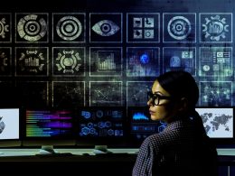 Analystin mit Nerd-Brille sitzt konzentriert vor Monitoren mit komplexen Datenvisualisierungen und GA4 Dashboards, während im Hintergrund Universal Analytics Symbole als Ruinen erscheinen.