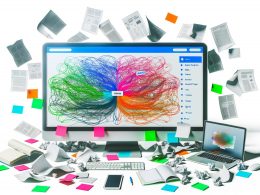 Digitaler Arbeitsplatz mit bunter Mindmap auf Monitor, geordneten Notizen, Laptop und Smartphone, im Kontrast zu chaotischen Website-Elementen im Hintergrund.