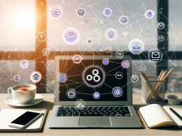 Minimalistischer Arbeitsplatz eines Solopreneurs mit Laptop auf Gumroad-Dashboard, Kaffee, Smartphone mit Verkaufsmeldungen und abstrahierten Automatisierungs-Icons.