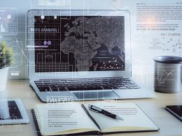 Moderner Arbeitsbereich mit Laptop, auf dem ein übersichtliches Machine Learning-Diagramm angezeigt wird, sowie verschwommenen digitalen Marketinggrafiken im Hintergrund und einem Notizbuch mit Kaffeebecher im Vordergrund.