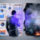 Geschäftsperson in Anzug vor Bildschirm mit digitalen KPIs, Heatmaps und Conversion Funnels, im Vordergrund verbrennende Papierfetzen mit 'Bauchgefühl' und 'Intuition', digitale Großstadt im Hintergrund.