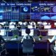 Moderne Redaktion im digitalen Newsroom mit Journalisten, die vor Computern und großen Bildschirmen mit SEO-Analysen, Diagrammen und Google-Rankings arbeiten.