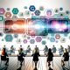 Futuristisches Marketing-Setting mit digitalem Dashboard, Datenvisualisierungen und Marketers an Laptops, umgeben von klassischen und digitalen Medien.